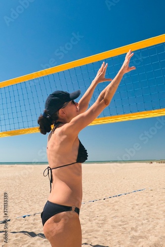 girl playing beach volleyball on the seashore