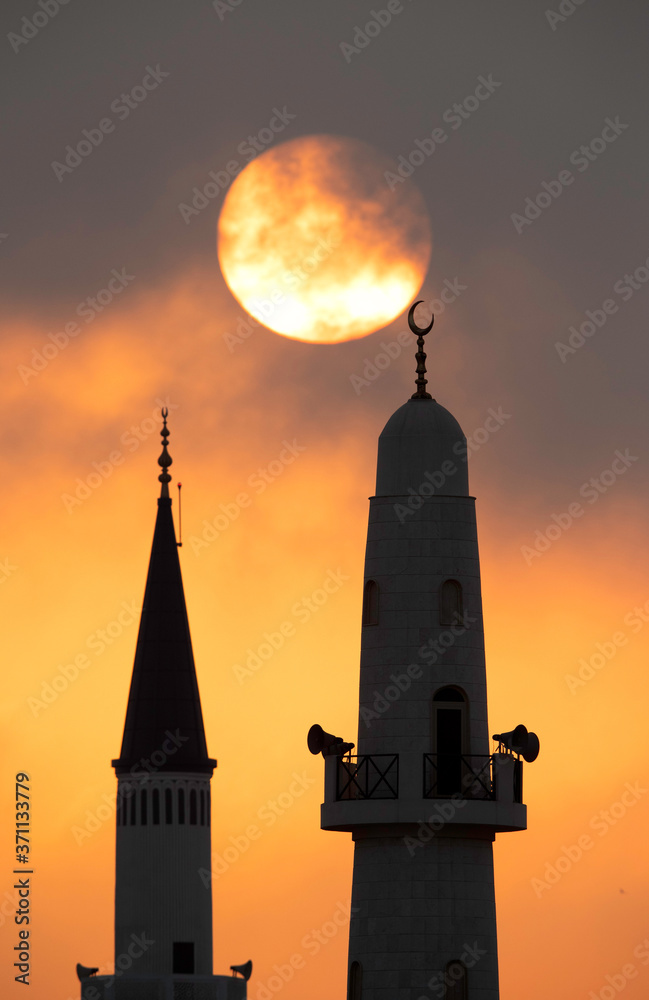 Naklejka premium Sunrise projecting the beautiful silhouette of a minaret, Bahrain