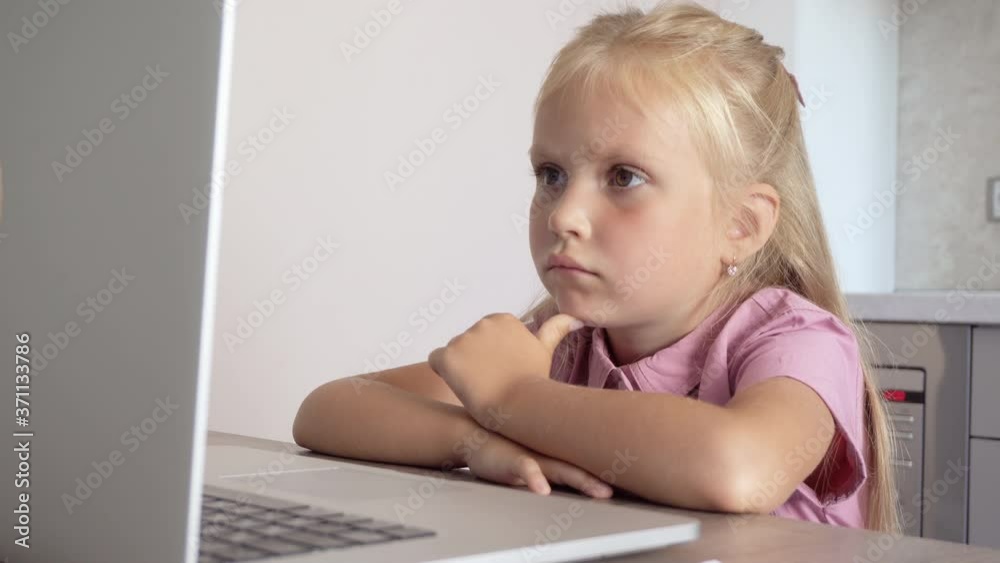 The girl is studying remotely using a computer. Online lesson for children The girl is studying remotely using a computer. Online lesson for children