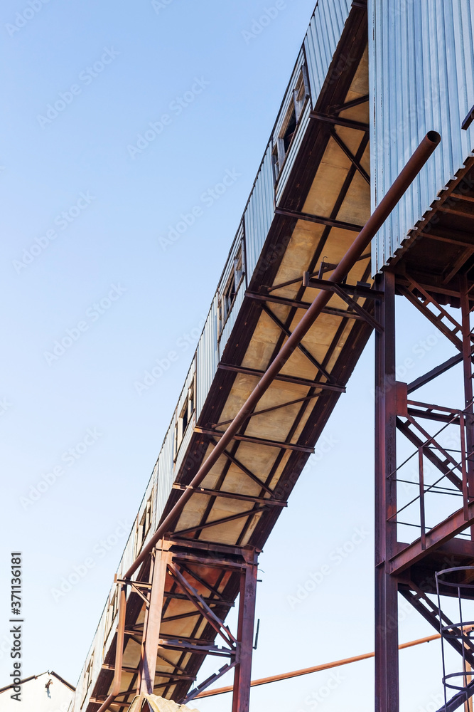 Old, abandoned concrete plant with iron rusty tanks and metal structures. The crisis, the fall of the economy, stop production capacity led to the collapse. Global catastrophe.