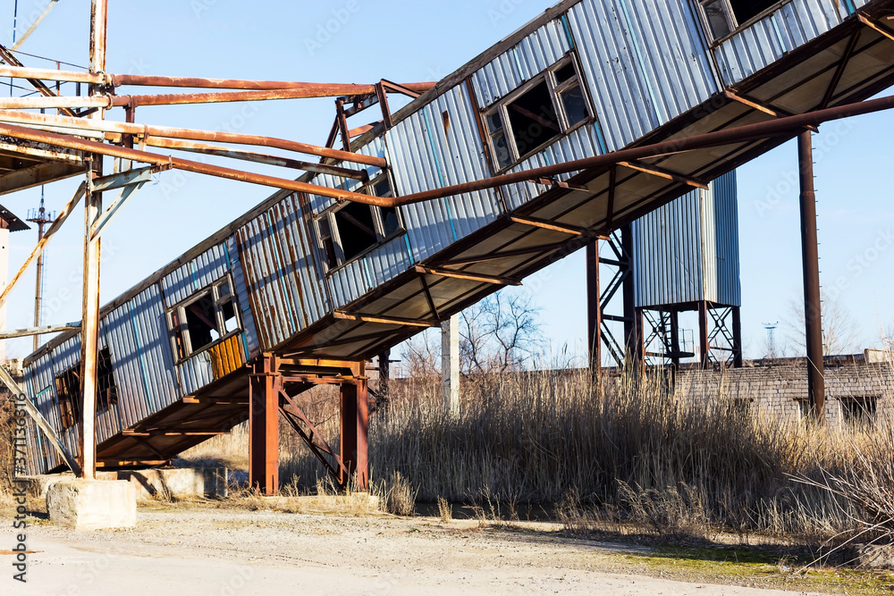 Old, abandoned concrete plant with iron rusty tanks and metal structures. The crisis, the fall of the economy, stop production capacity led to the collapse. Global catastrophe. Old, abandoned concrete plant with iron rusty tanks and metal structures. The crisis, the fall of the economy, stop production capacity led to the collapse. Global catastrophe.