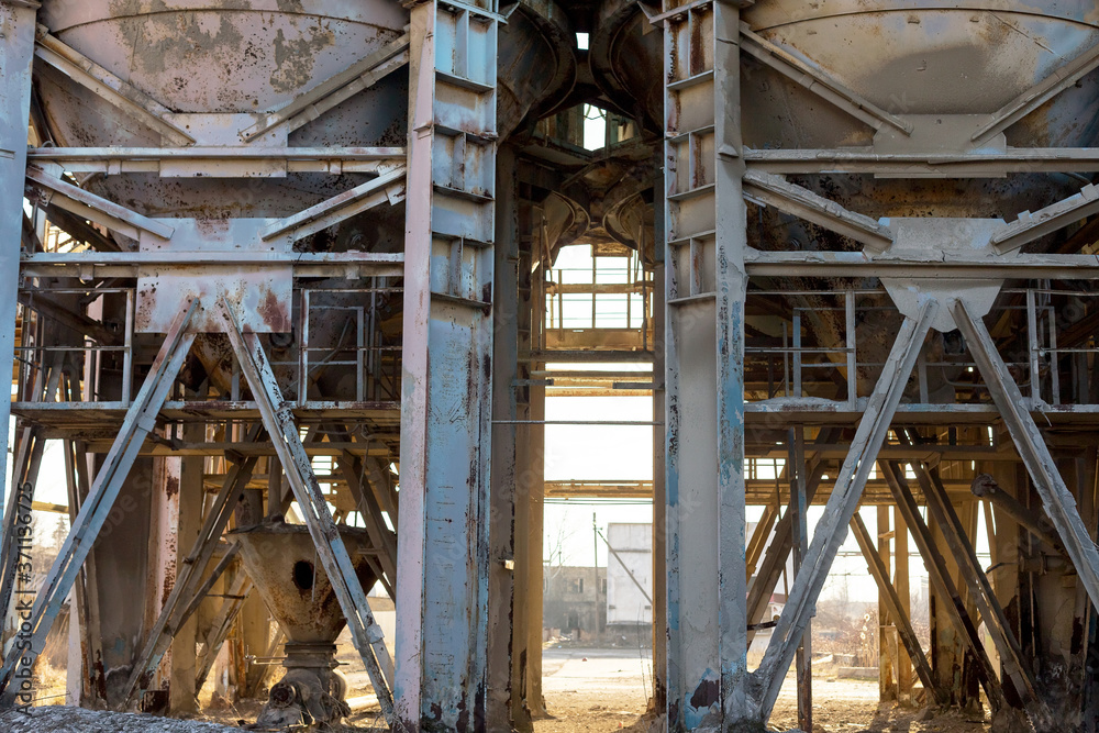 Old, abandoned concrete plant with iron rusty tanks and metal structures. The crisis, the fall of the economy, stop production capacity led to the collapse. Global catastrophe.