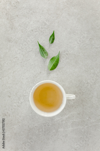 Cup of fresh green tea with tea leaves. Flat lay, top view. Tea concept