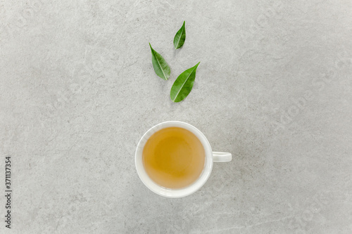 Cup of fresh green tea with tea leaves. Flat lay, top view. Tea concept © K.Decor