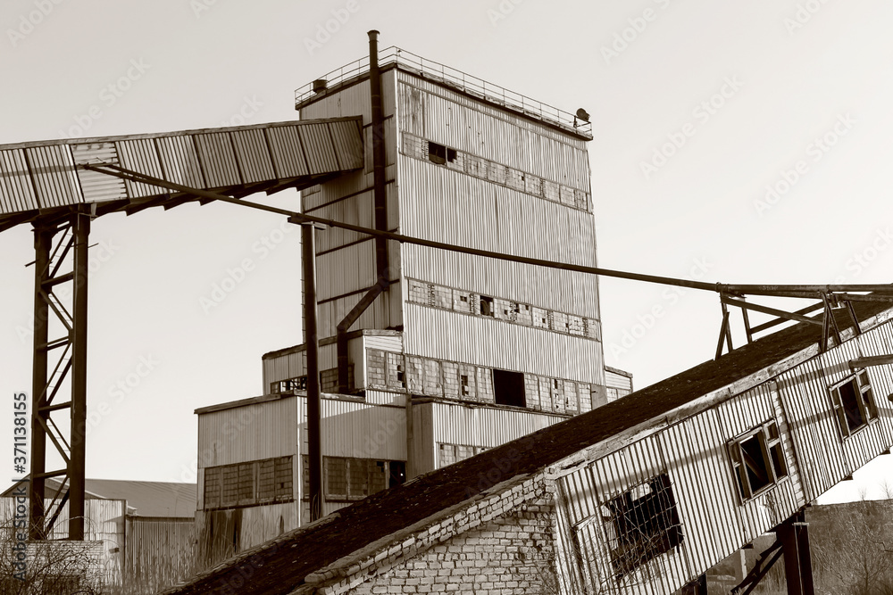 Old, abandoned concrete plant with iron rusty tanks and metal structures. The crisis, the fall of the economy, stop production capacity led to the collapse. Global catastrophe. Old photo effect Old, abandoned concrete plant with iron rusty tanks and metal structures. The crisis, the fall of the economy, stop production capacity led to the collapse. Global catastrophe. Old photo effect