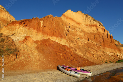 Picturesque sunset landscape of Stanislav mountains and the Black sea beach with two baidarka or kayak boats, Ukraine photo