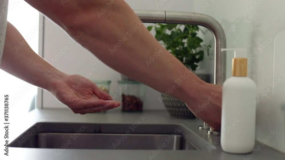 Mann wäscht sich am Waschbecken gründlich die Hände mit Seife