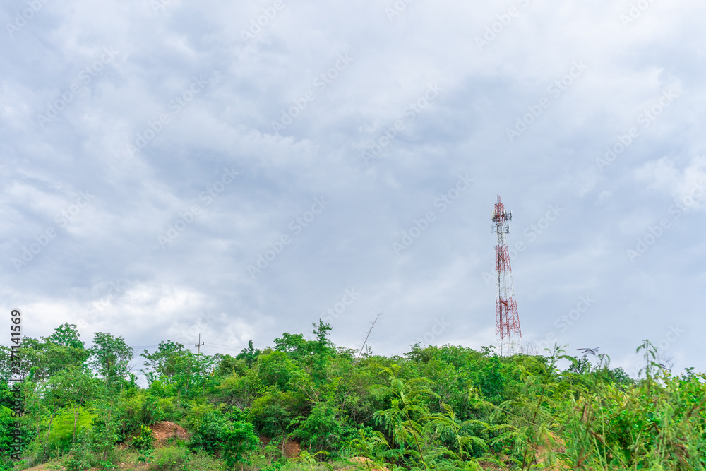 Telephone tower Internet signal The red color on the mountain top With a blue sky background With dense clouds