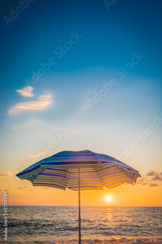 Beach umbrella by the sea. Sunset on the beach. A colorful, large awning to protect from the sun's rays. Summer. Day. Georgia. Black Sea.