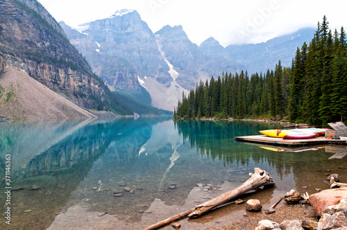 Moraine Lake with boats on the shore on a cloudy day. Banff National Park, Canada