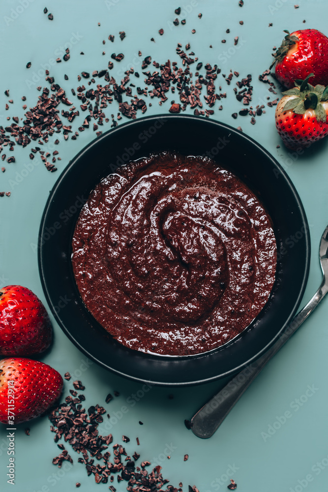 Delicious Keto Chocolate Porridge with some Chocolate bits and strawberries