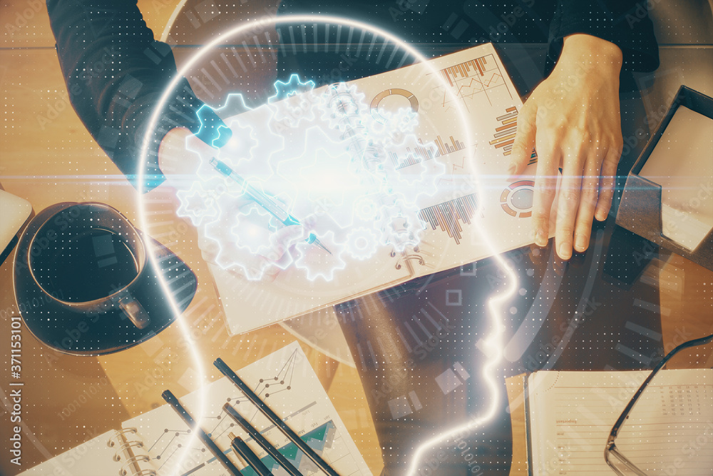 Multi exposure of woman's writing hand on background with brain hologram. Concept of brainstorming.