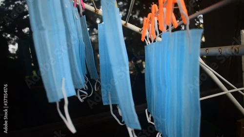 Video footage of reusable masks hanging on a stand with clips plugged . corona virus pandemic masks