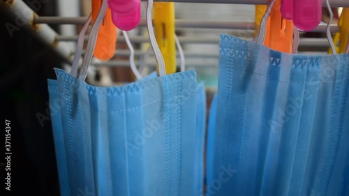 Video footage of reusable masks hanging on a stand with clips plugged . corona virus pandemic masks