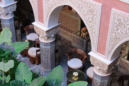 Top view of the Moroccan Riad with original tables and chairs, carved arches and mosaic columns, Marrakech, Morocco