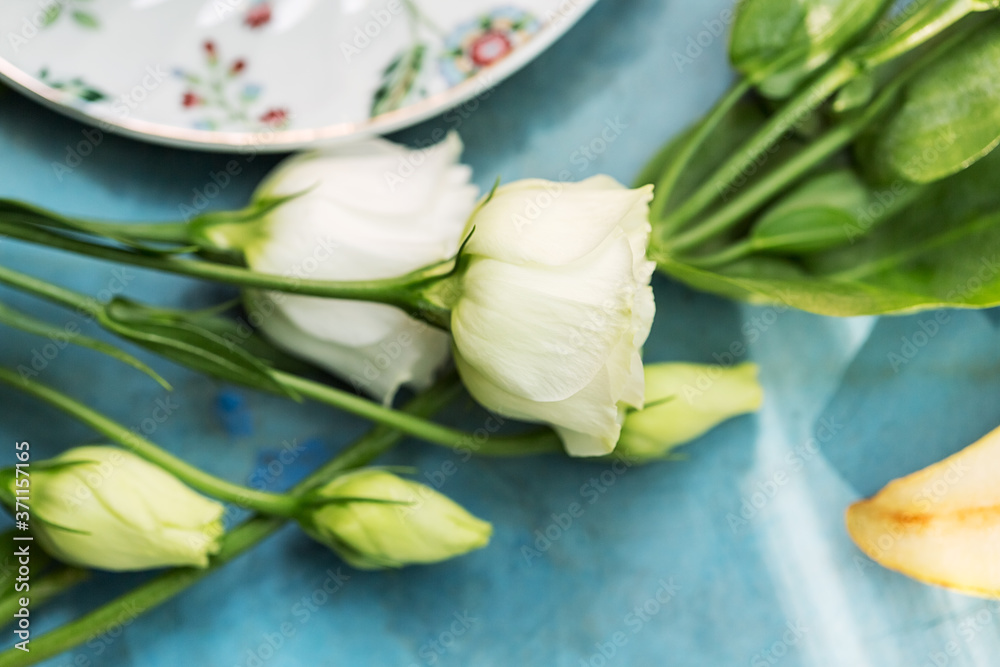 White roses on blue table near tea White roses on blue table near tea