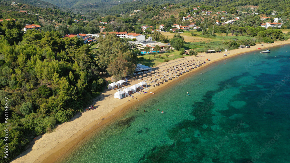 Aerial drone photo of famous organised with sun beds and umbrellas sandy beach of Agia Paraskevi in island of Skiathos, Sporades, Greece