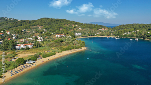 Aerial drone photo of famous organised with sun beds and umbrellas sandy beach of Agia Paraskevi in island of Skiathos, Sporades, Greece