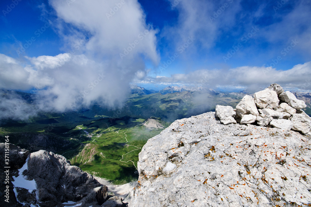 Alpine landscape with peaks and clouds. Mountain scenic road on background. Passo Rolle, Italy Alpine landscape with peaks and clouds. Mountain scenic road on background. Passo Rolle, Italy