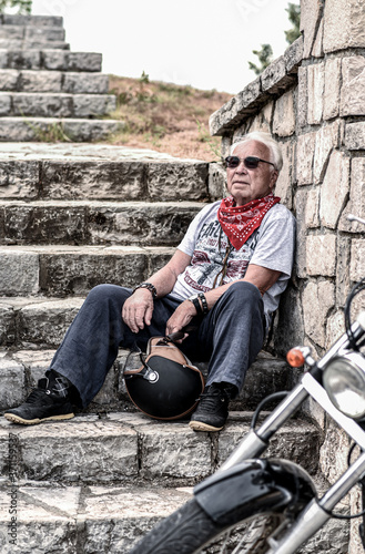 Old man on a motorcycle in the mountains