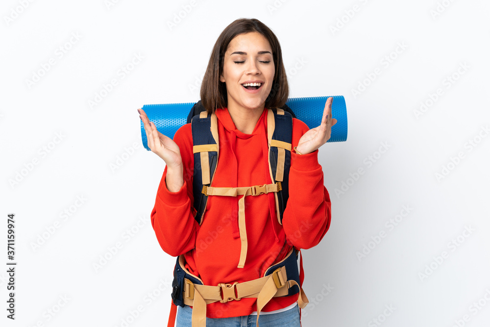 Young caucasian mountaineer girl with a big backpack isolated on white background laughing Young caucasian mountaineer girl with a big backpack isolated on white background laughing
