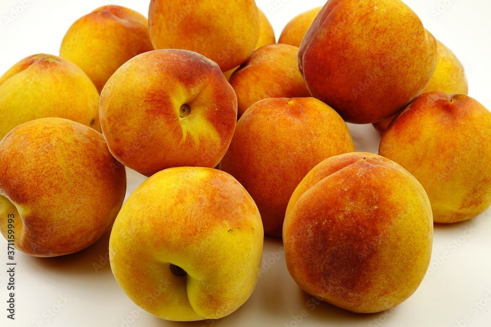 Ripe juicy peach lie on a white table Ripe juicy peach lie on a white table