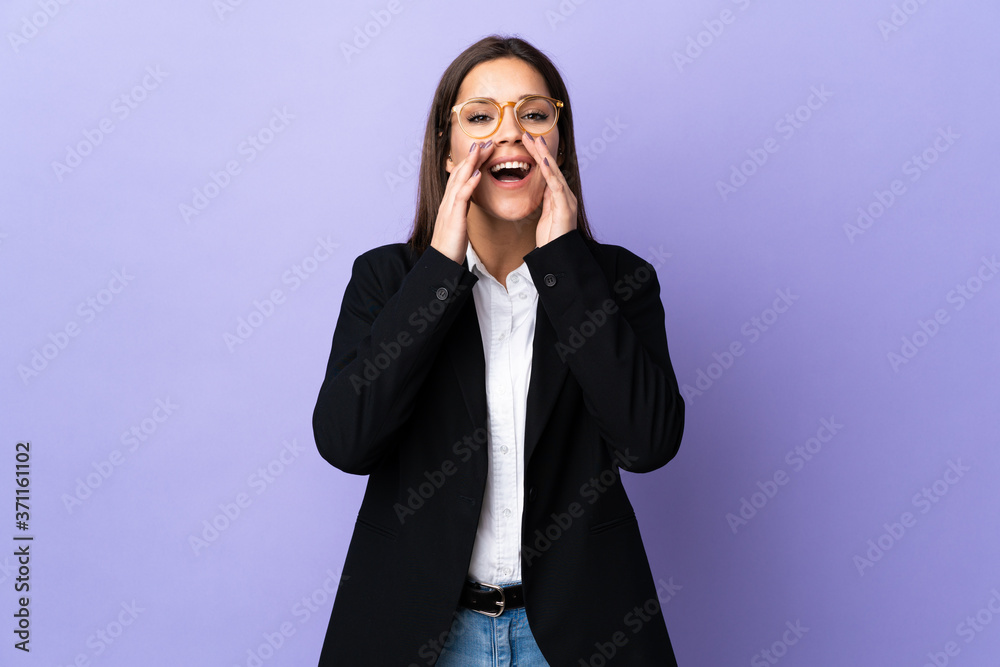 Business woman isolated on purple background shouting and announcing something Business woman isolated on purple background shouting and announcing something