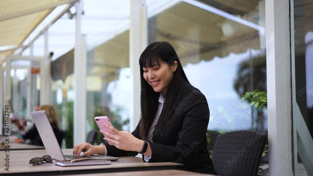 Business asian woman using mobile phone while working from bar table outdoor - Slow Motion Business asian woman using mobile phone while working from bar table outdoor - Slow Motion