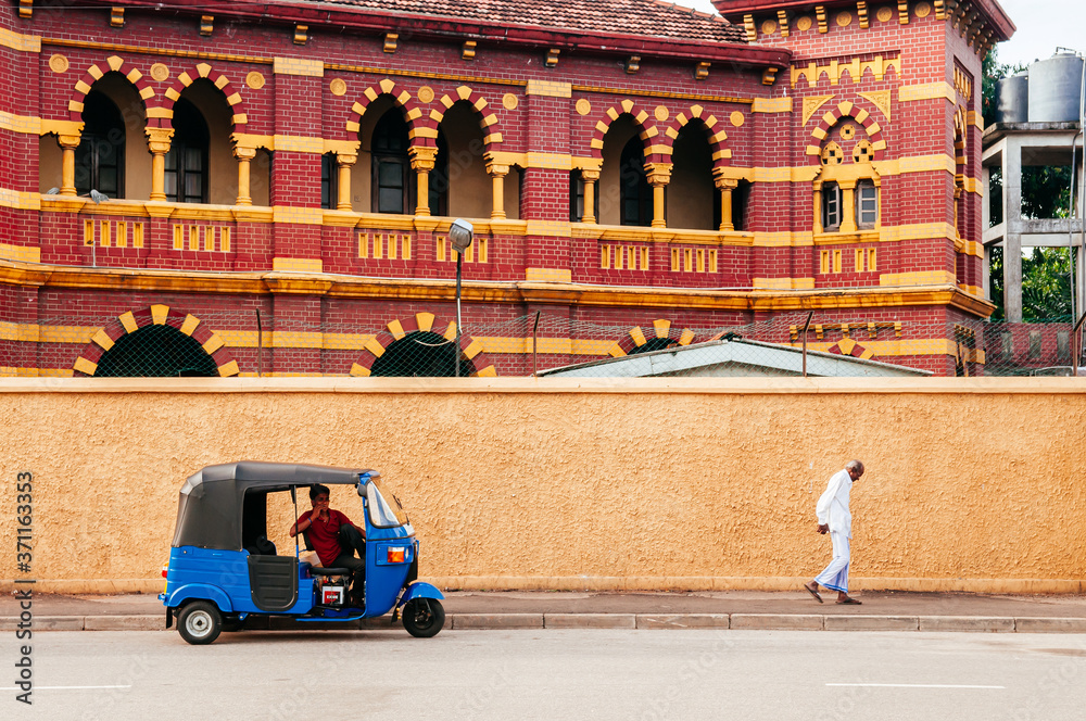 Victoria Memorial Building and auto rickshaw or Bajaj three wheeler on street in Colombo, Sri Lanka