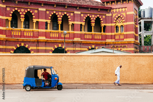 Victoria Memorial Building and auto rickshaw or Bajaj three wheeler on street in Colombo, Sri Lanka photo