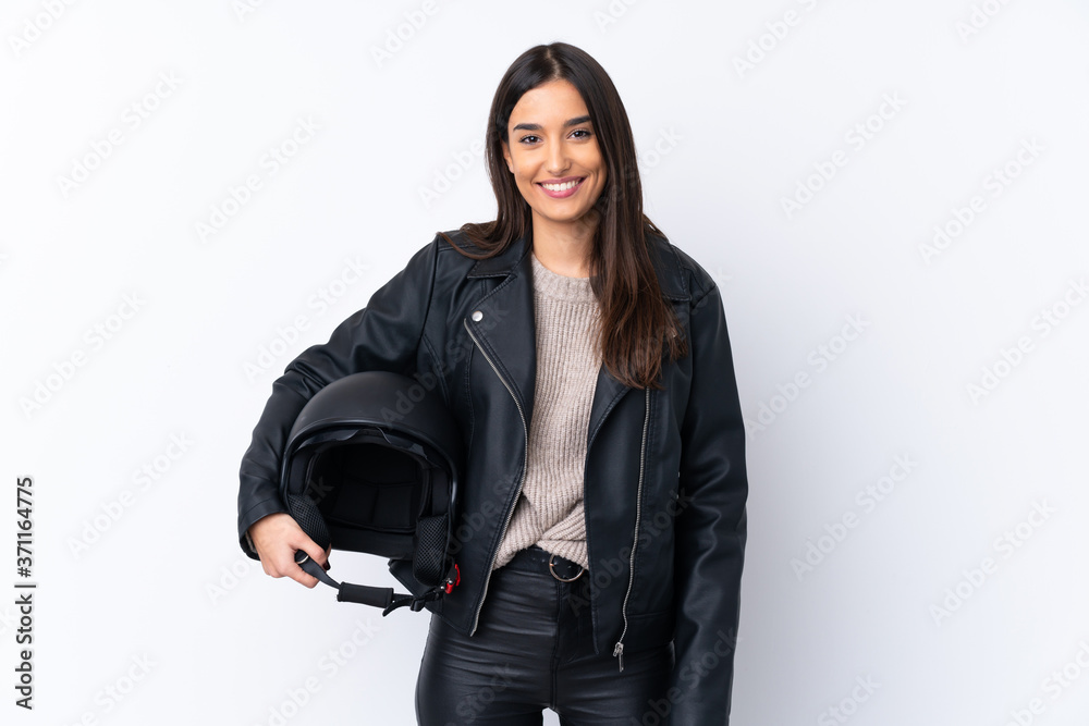Young brunette woman with a motorcycle helmet over isolated white background smiling a lot - obrazy, fototapety, plakaty 