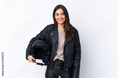 Young brunette woman with a motorcycle helmet over isolated white background smiling a lot
