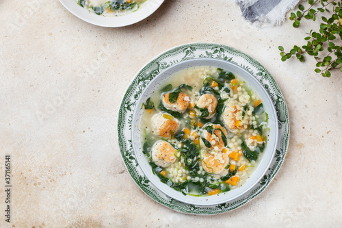 Italian wedding soup with meatballs and ptitim paste photo