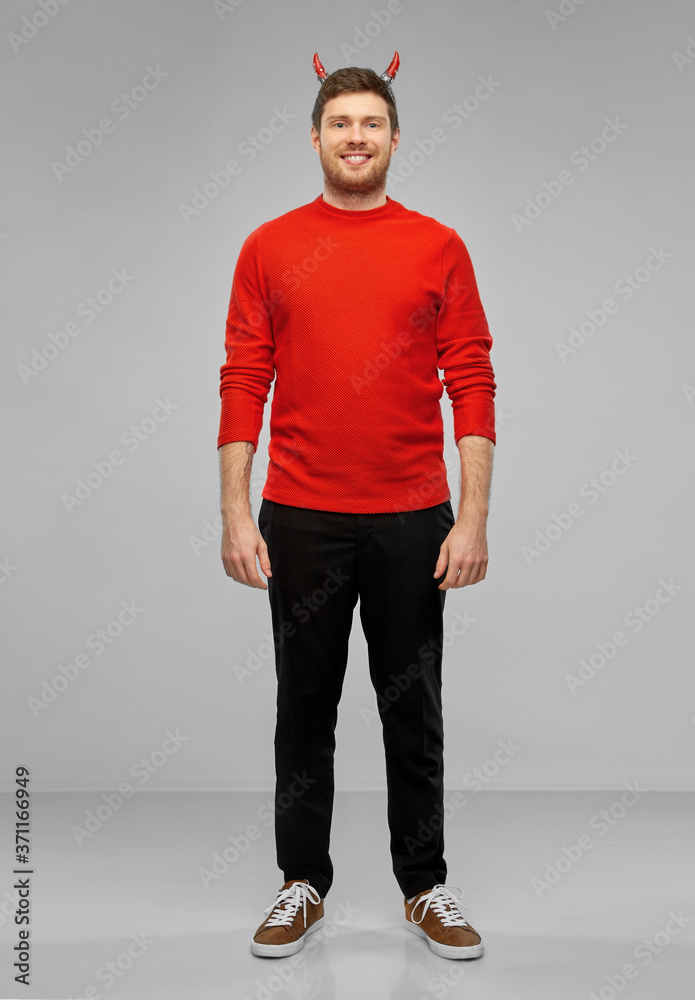 holiday, theme party and people concept - happy smiling man in halloween costume of devil over grey background holiday, theme party and people concept - happy smiling man in halloween costume of devil over grey background