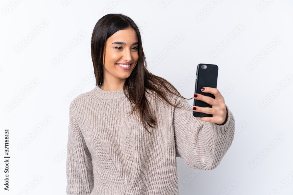 Young brunette woman over isolated white background making a selfie Young brunette woman over isolated white background making a selfie
