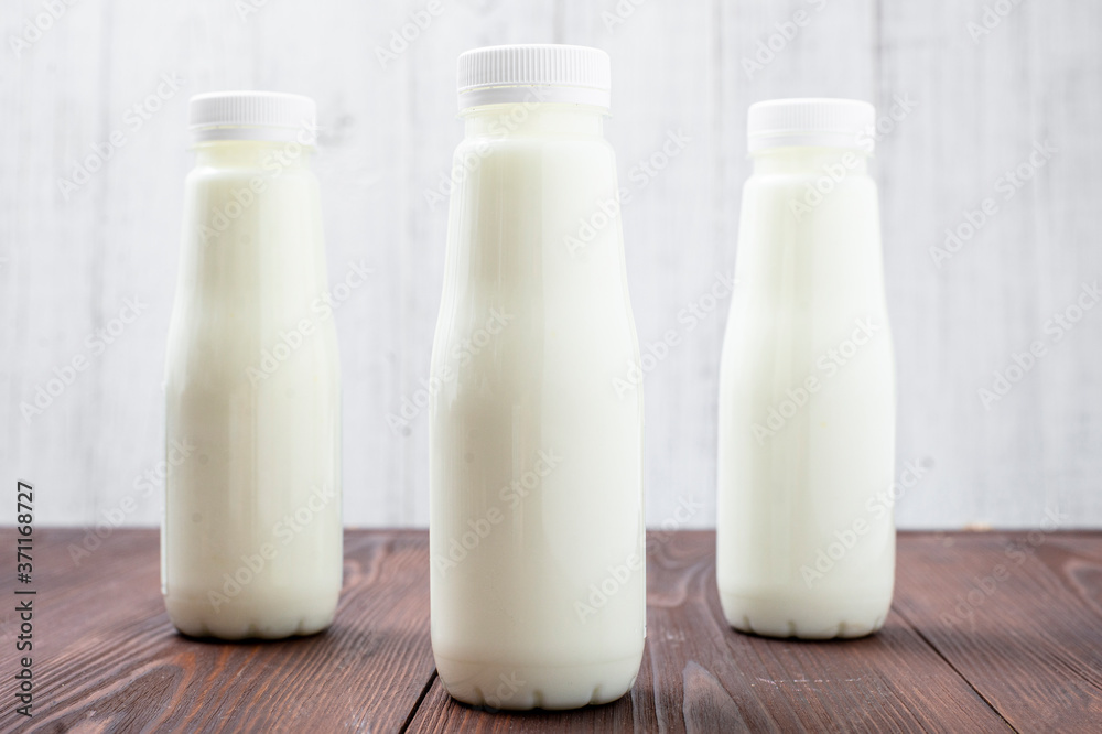 Bottles with milk, yogurt on a light background. Natural dairy products. Bottles with milk, yogurt on a light background. Natural dairy products.