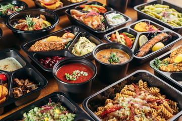 group of food in plastic dish on table. take away food