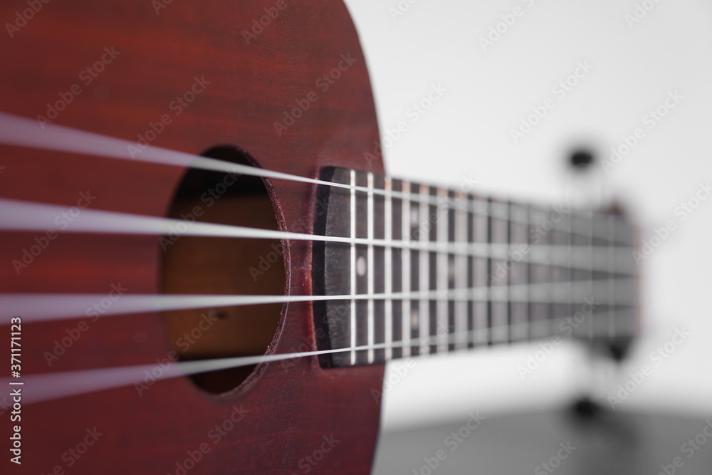 Ukulele guitar made of wood on white background. 4 strings of voice used to deck playing music to relax.