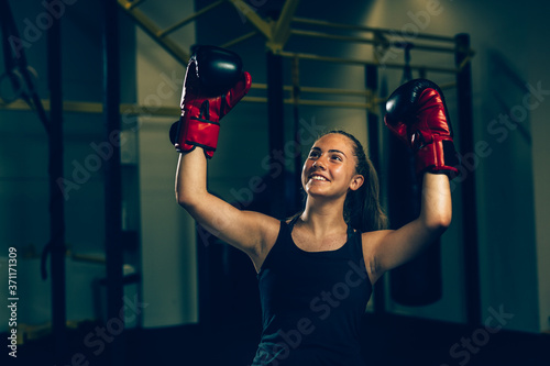 kickboxing woman holding hands up in gym
