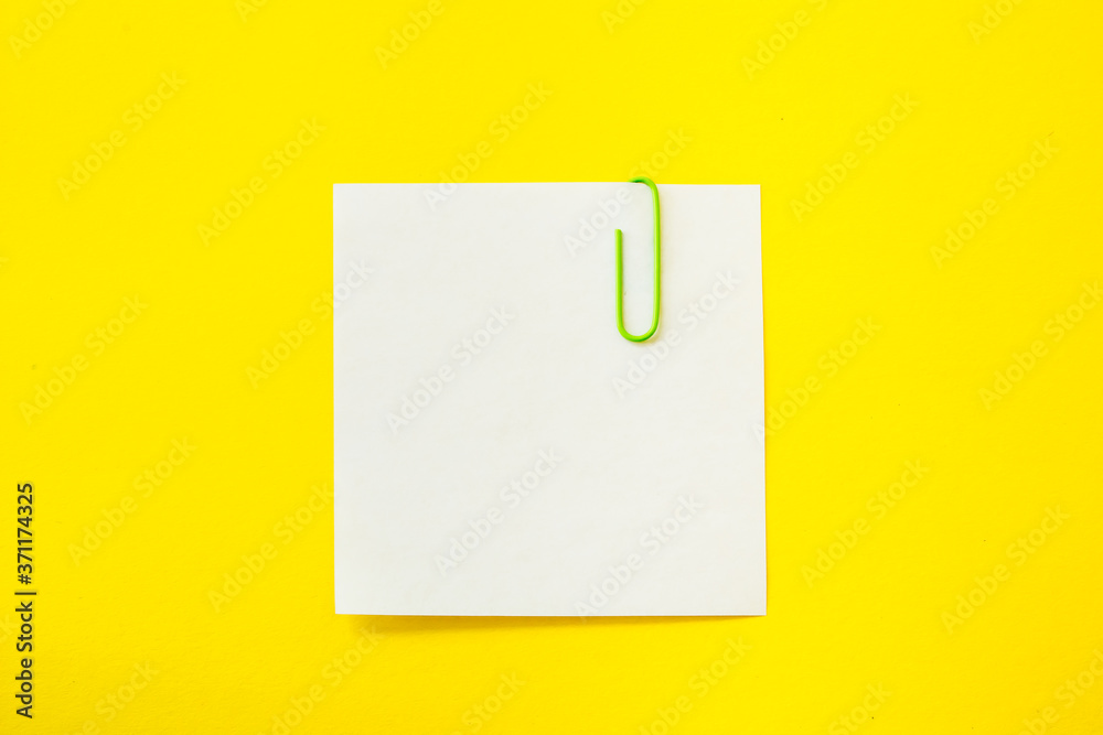 note sheet with paper clip on yellow background note sheet with paper clip on yellow background