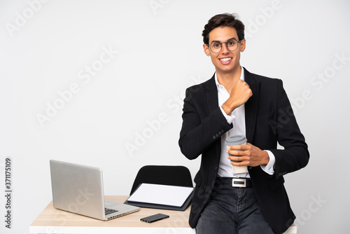 Businessman in his office over isolated white background celebrating a victory