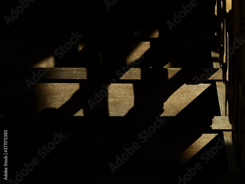 Shadow on the wooden staircase in the home with sunlight from window
