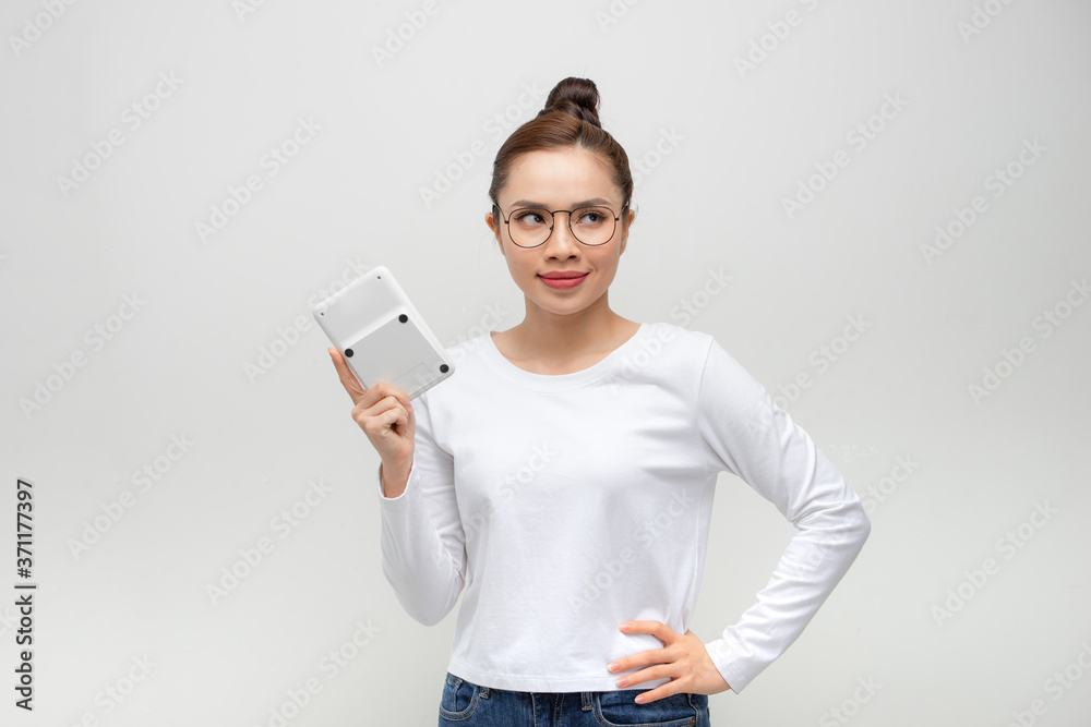 young woman looking at the camera with a calculator in hand young woman looking at the camera with a calculator in hand