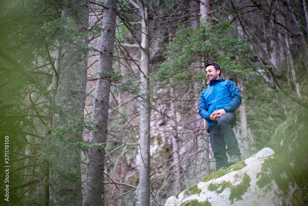 Obraz premium Experienced hiker sitting on rock taking a break from hiking