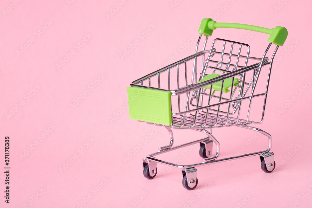 Empty top view mini pink shopping cart or trolley shopping on pink background Empty top view mini pink shopping cart or trolley shopping on pink background