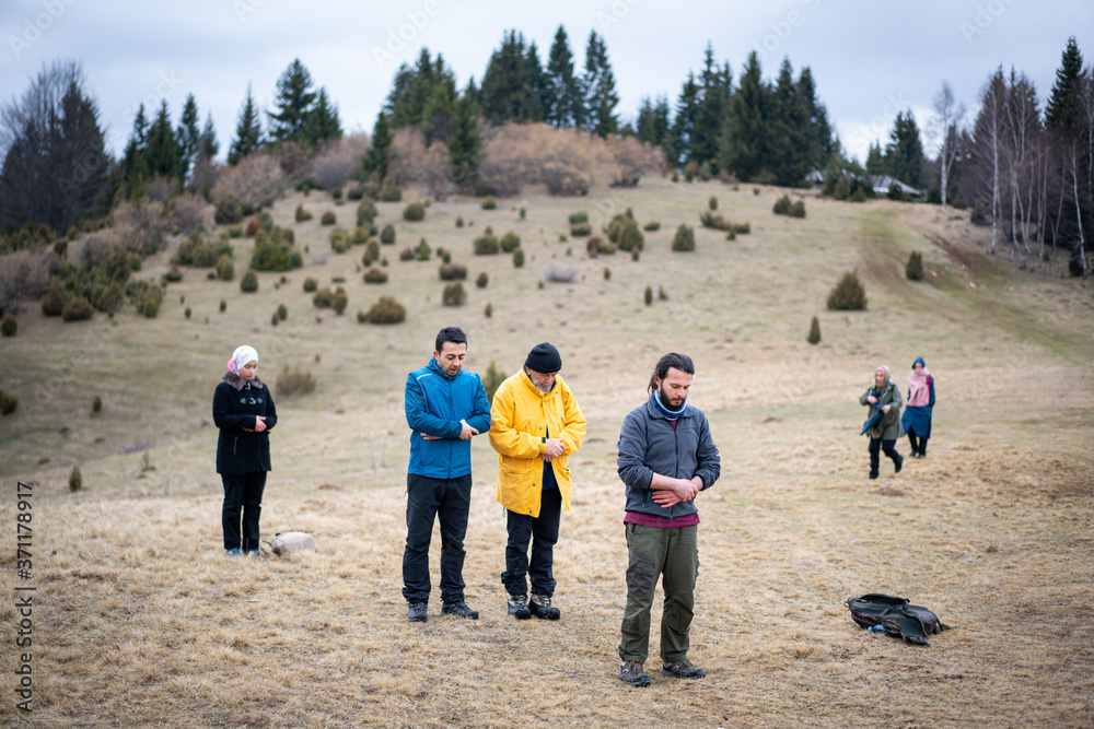 A group of muslim people praying in nature