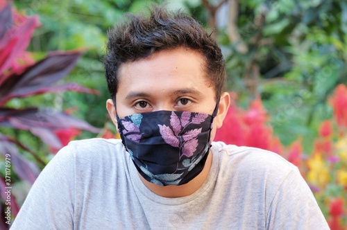 man wearing diy cloth face mask in outdoor with blurry background