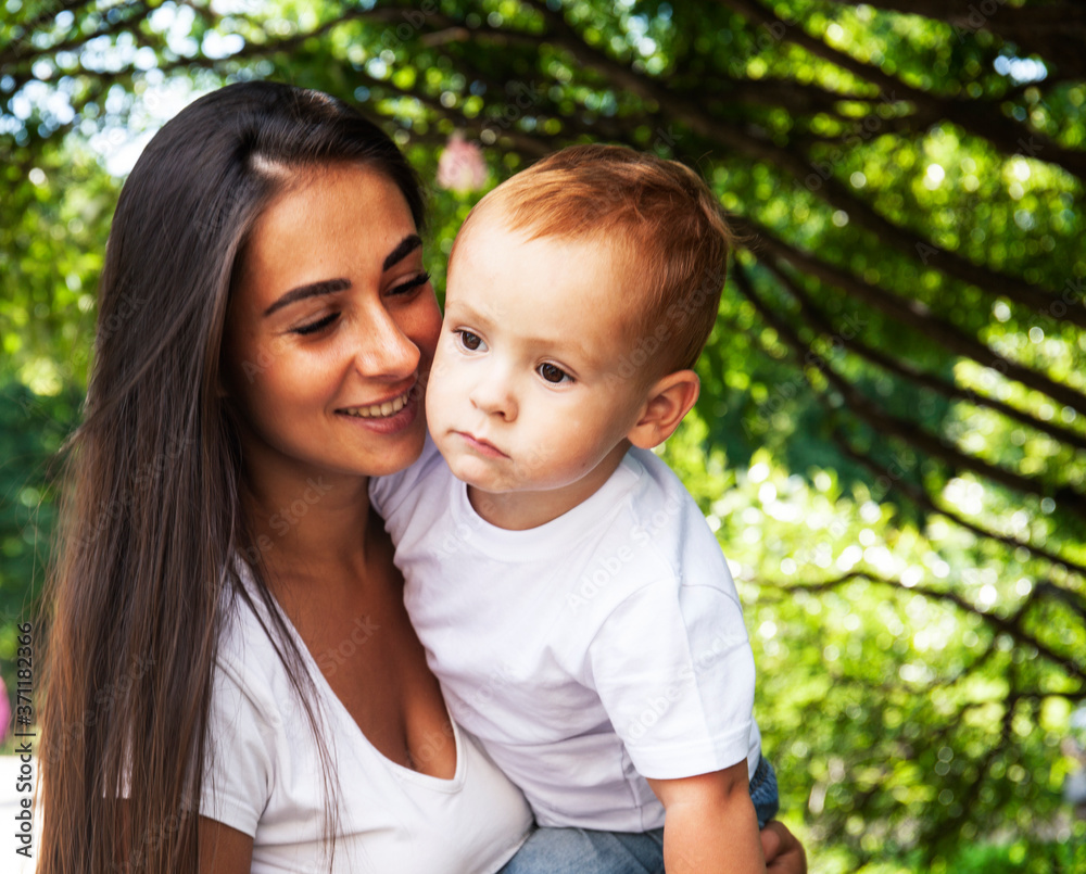 young pretty brunette mother with little cute boy walking in park happy smiling, lifestyle people concept young pretty brunette mother with little cute boy walking in park happy smiling, lifestyle people concept