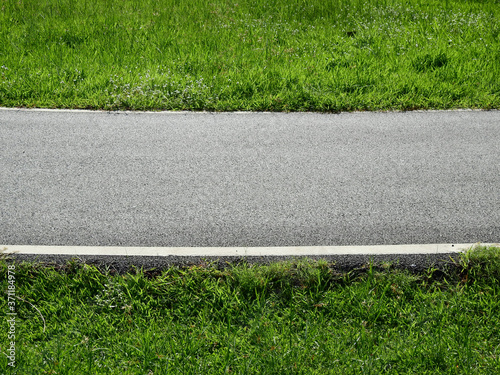 asphalt road with green grass of field