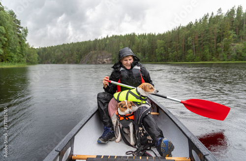 Woman canoeing at the lake with dog in Finland 